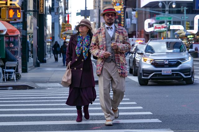 a stylish couple crosses a street in Midtown